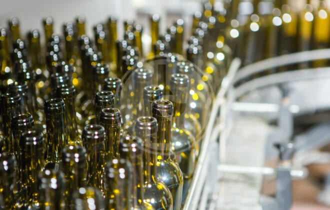 unlabeledglassbottlesinbottlingmachineatmodernwinery